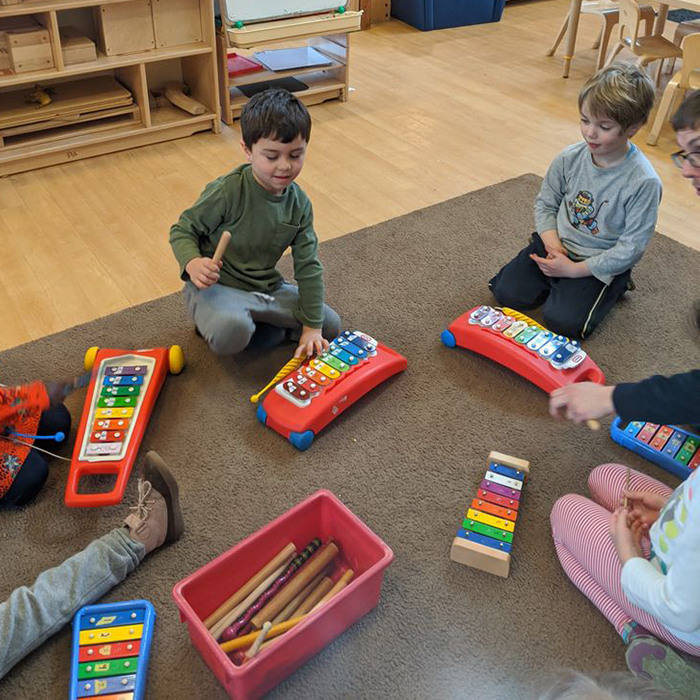 little boys playing with musical instruments in group
