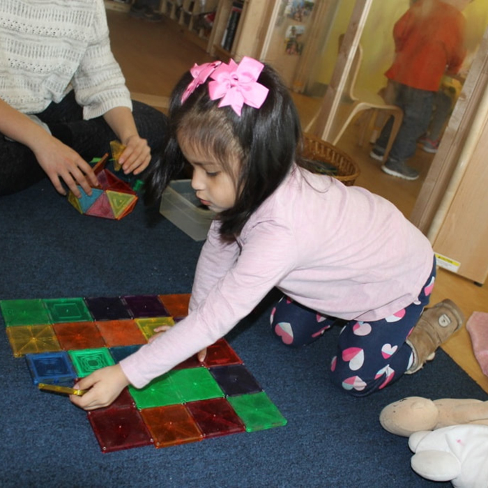 young girl playing a game on carpet