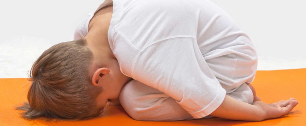 young boy in a yoga pose