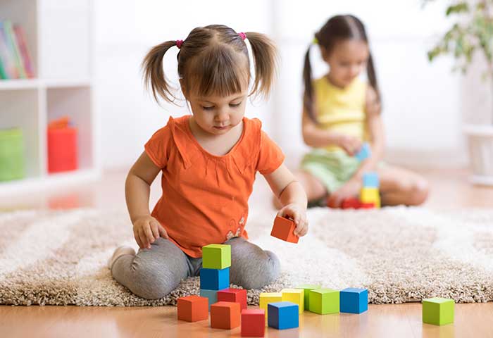 toddler girl playing with blocks of different colors