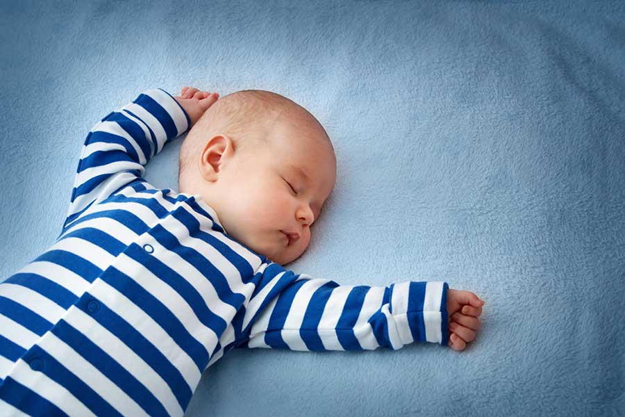 resources for sleeping, newborns, baby in stripped onsie sleeping, blue background